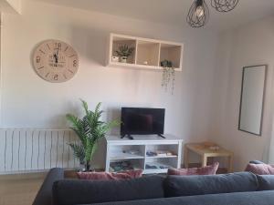 a living room with a couch and a clock and a tv at Aromas del Jiloca in Calamocha