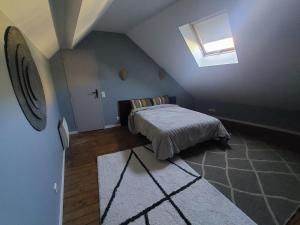 a attic bedroom with a bed and a skylight at Le Palais Des Marins in Châteauroux