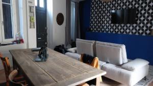 a living room with a wooden table and a couch at Le Palais Des Marins in Châteauroux