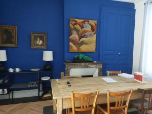 a dining room with blue walls and a wooden table at Le Palais Des Marins in Châteauroux