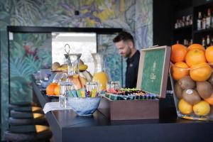 a man standing behind a counter with a buffet of fruit at VISIONAPARTMENTS Wolframplatz - self check-in in Zurich