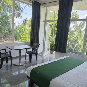 a bedroom with a bed and a table and a window at Kandy Fortress in Kandy