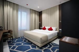 a hotel room with a large bed with red pillows at Рамада Нукус in Nukus