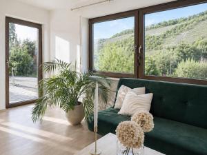 a living room with a green couch and a large window at Auszeit in Bullay