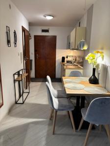 a kitchen and dining room with a table and chairs at Apartament Patio 50 m od plaży in Władysławowo