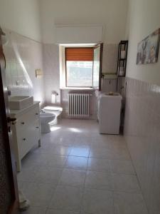 a bathroom with two sinks and a toilet and a window at BGM apartment Rho Fiera Milan in Cesate