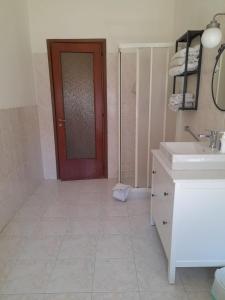 a bathroom with a sink and a red door at BGM apartment Rho Fiera Milan in Cesate