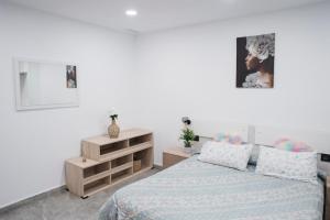 a bedroom with a bed and a dresser at Apart LA PLANA II in Castellón de la Plana