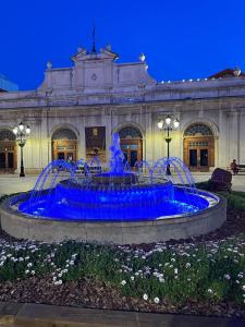 a fountain in front of a building with blue water at Apart LA PLANA II in Castellón de la Plana