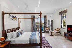 a bedroom with a canopy bed and a living room at Jolawas Stays Udaipur in Udaipur +42 photos