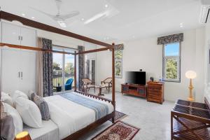 a bedroom with a bed and a table and a tv at Jolawas Stays Udaipur in Udaipur