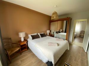 a bedroom with a large bed and a mirror at Frangipanier, Maison quartier calme, 1,5km de la plage, 6 pers in Les Sables-d'Olonne