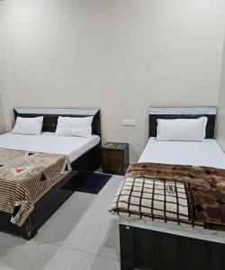 a room with two beds and a table at The Hotel Siddhi Residency near Ram Mandir in Ayodhya +45 photos