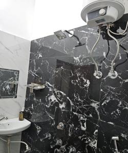 a bathroom with a black and white marble wall at The Hotel Siddhi Residency near Ram Mandir in Ayodhya