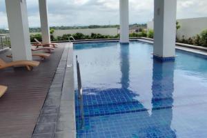 a swimming pool with lounge chairs on the deck of a hotel at Polished Studio at The Verdin Maple Grove in General Trias