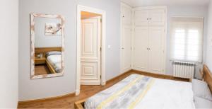 a bedroom with a mirror and a bed at Piso de Verano en El Tiemblo in El Tiemblo +6 photos