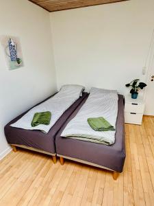 a bed with two green towels on it in a room at PRIVATE B&B - EASY ACCESS - 24h SELF CHECK IN-OUT in Odense
