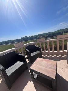 a patio with two chairs and a table on a balcony at maison de loire in Villebernier