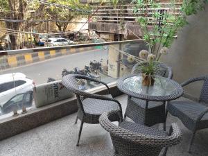 a table and chairs on a balcony with a view of a street at Gianmala Residency South Ex New Delhi in New Delhi