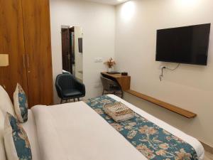 a hotel room with a bed and a flat screen tv at Gianmala Residency South Ex New Delhi in New Delhi +20 photos