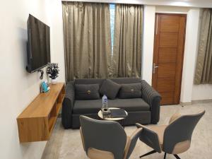 a living room with a couch and a table and chairs at Gianmala Residency South Ex New Delhi in New Delhi