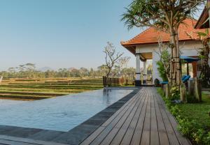 a house with a swimming pool next to a house at Umah Sunset in Ubud