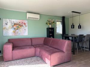 ein Wohnzimmer mit einem rosa Sofa und einem Tisch in der Unterkunft J 171 in Petten