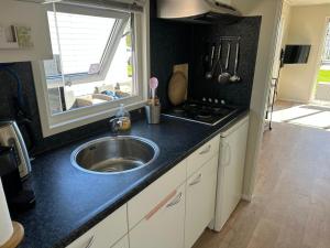 eine Küchentheke mit Spüle und Fenster in der Unterkunft J 171 in Petten