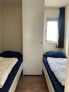 zwei Betten in einem kleinen Zimmer mit Fenster in der Unterkunft J 171 in Petten + 11 Fotos