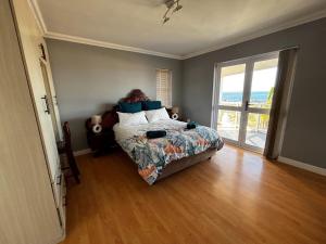 a bedroom with a bed with a view of the ocean at Wild Thyme in St Helena Bay in West Point