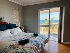 a bedroom with a bed with a view of the ocean at Wild Thyme in St Helena Bay in West Point
