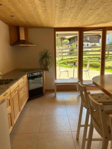 a kitchen with a table and chairs and a table at 2-Zimmer Ferienwohnung,Parterre,Sitzplatz,Garage in Adelboden