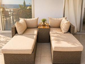 two wicker couches sitting on a balcony with a table at Casa del Sol Jacuzzi privado y vistas al Mediterráneo en Altea Hills in Altea