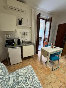 a kitchen with a table and a sink and a table and chairs at Dei Meravigli in Bari