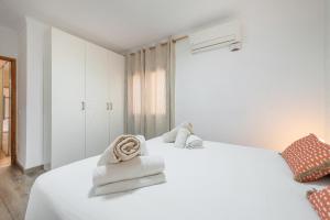 a bedroom with a white bed with towels on it at Can Calco old town in Alcudia