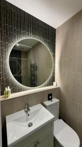a bathroom with a white sink and a mirror at The Edge Of The Beach in Bude +89 photos