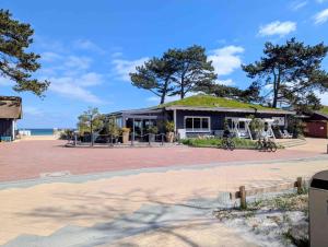 a building with a green roof on the beach at Panorama-Meerblick am Scharbeutzer Strand in Scharbeutz