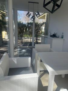 a white dining room with a white table and chairs at Pokoje Gościnne Akwatel in Jastarnia