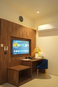 a room with a tv and a desk and a chair at Sunset BnB Ramna Islamabad in Islamabad