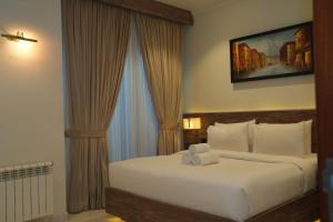 a bedroom with a large bed with white sheets at Sunset BnB Ramna Islamabad in Islamabad +26 photos