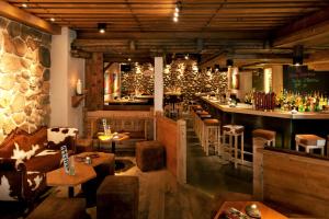 a restaurant with a bar with tables and chairs at Eiger Guest House - Grindelwald in Grindelwald