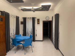 a dining room with a blue table and chairs at The Yarl Home in Jaffna