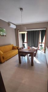 a living room with a table and a yellow couch at Casa Alois in Caserta