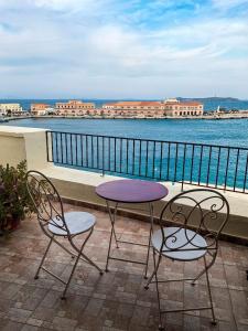 two chairs and a purple table and chairs on a balcony at Boutique Florence in Ermoupoli