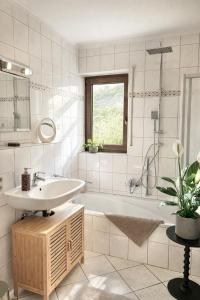 a white bathroom with a sink and a tub at Auszeit in Bullay