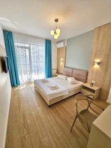 a hotel room with a bed and a chair in it at Marconi Premium Apartments in Mamaia