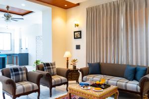 a living room with a couch and two chairs and a table at Jolawas Stays Udaipur in Udaipur