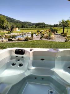 a white bath tub with a view of a garden at B&B La Barbatella in Palazzo Canavese +5 photos