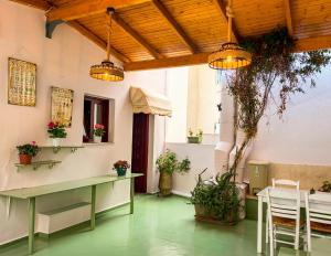a room with tables and chairs and potted plants at Boutique Florence in Ermoupoli