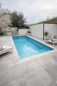 a swimming pool in a backyard with a patio furniture at SeaViewPeramou in Elevtheraí